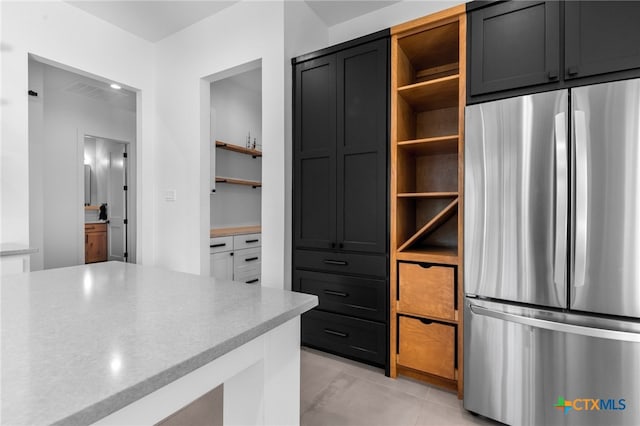 kitchen featuring stainless steel fridge and light tile patterned flooring