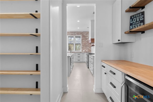 interior space with light tile patterned flooring, sink, and beverage cooler