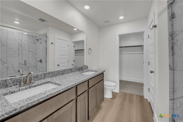 bathroom with hardwood / wood-style floors, vanity, toilet, and an enclosed shower