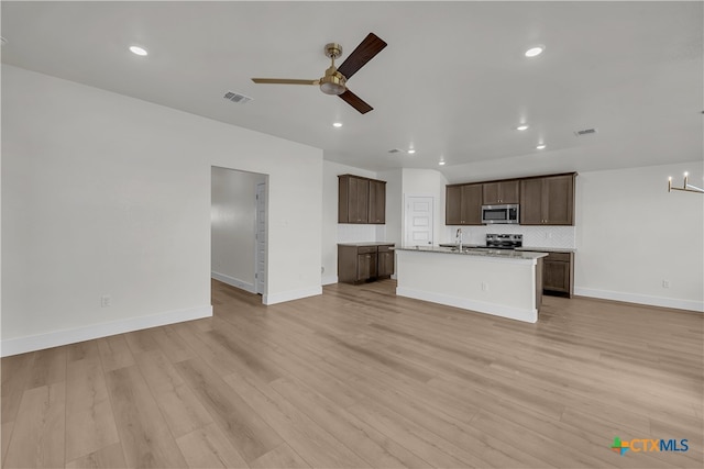 unfurnished living room with ceiling fan with notable chandelier, light wood-type flooring, and sink