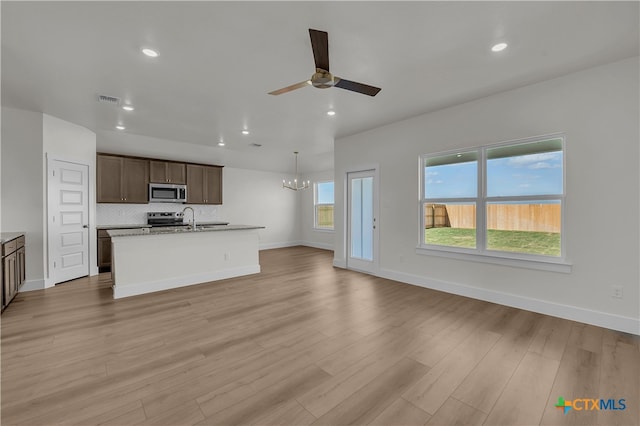 interior space with ceiling fan with notable chandelier, light hardwood / wood-style flooring, and a healthy amount of sunlight