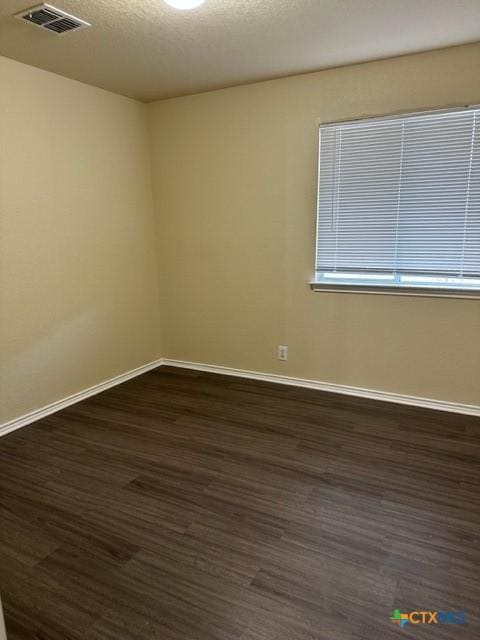 221 Roadrunner Ave, New Braunfels, TX 78130 - unfurnished room with dark wood-style flooring and a textured ceiling