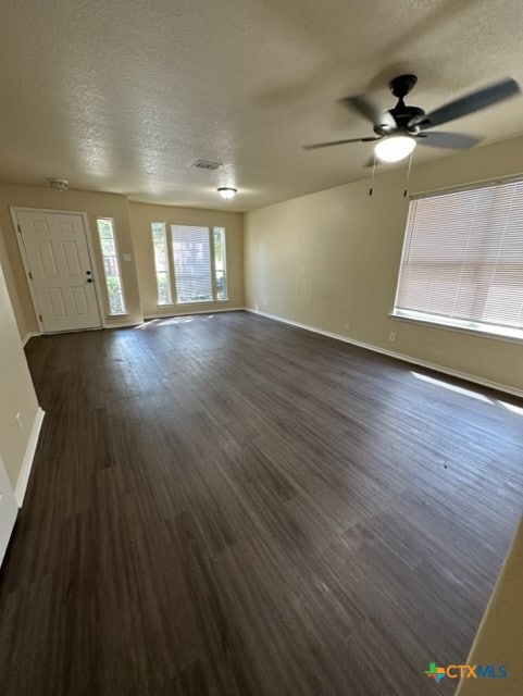 221 Roadrunner Ave, New Braunfels, TX 78130 - unfurnished living room with a textured ceiling, dark wood-style floors, and a ceiling fan