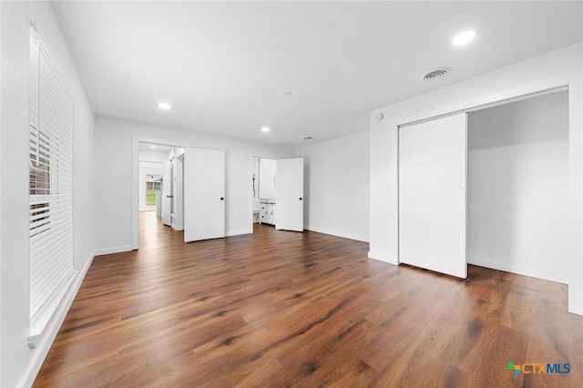 unfurnished bedroom with dark wood-type flooring