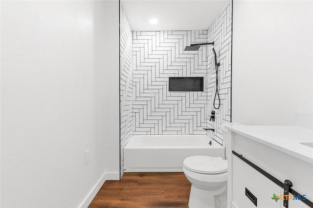 full bathroom with vanity, tiled shower / bath, wood-type flooring, and toilet