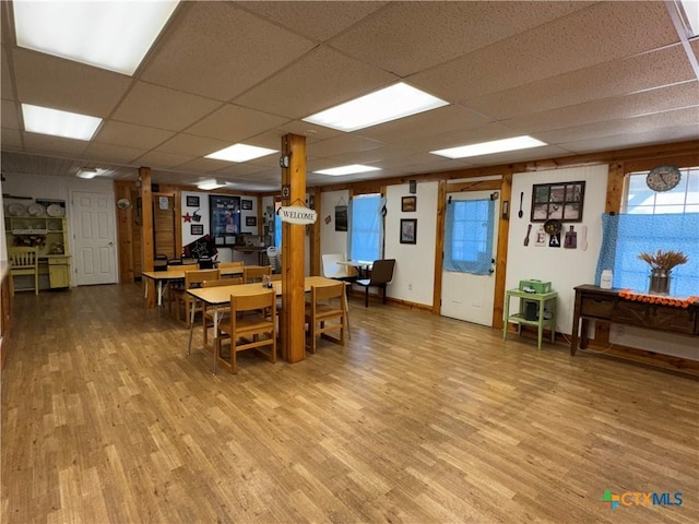 dining room with wood finished floors, baseboards, and a paneled ceiling