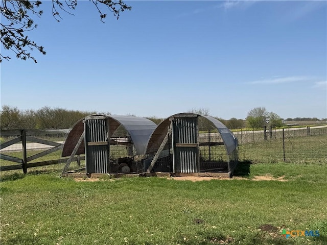 view of play area with exterior structure, an outdoor structure, a yard, and fence