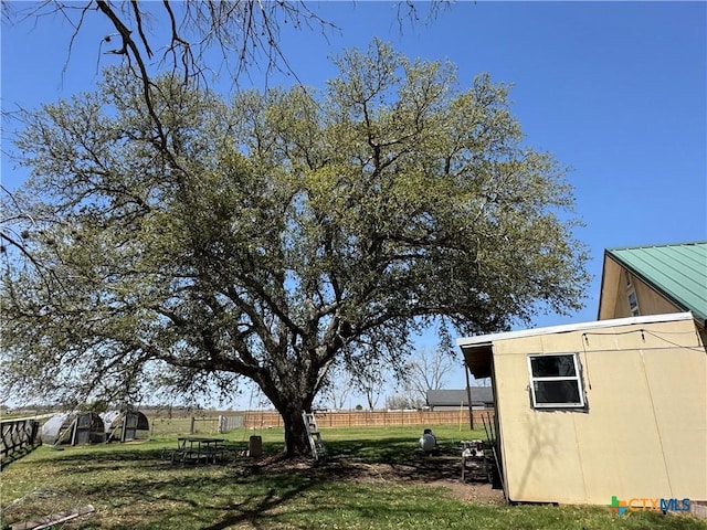 view of yard with a storage shed, an outdoor structure, and fence