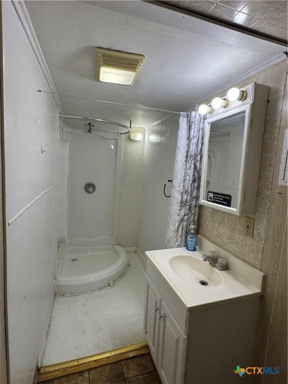 full bathroom with vanity, a shower stall, and visible vents