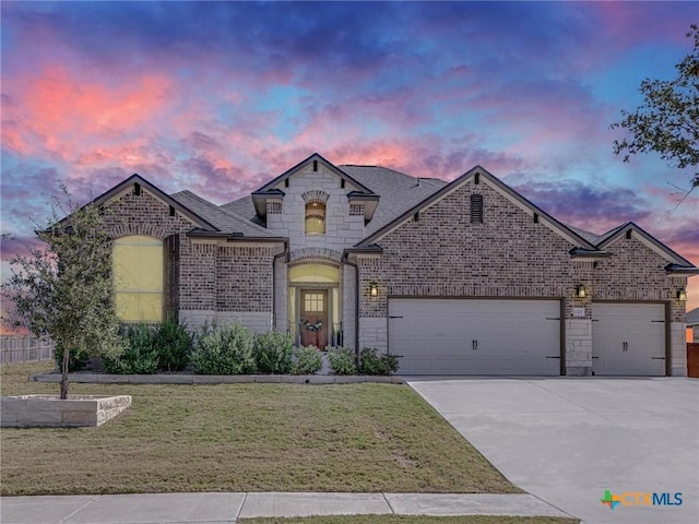 1701 Meadow Crest Dr, Salado, TX 76571 - french country inspired facade with a garage, concrete driveway, a yard, brick siding, and stone siding