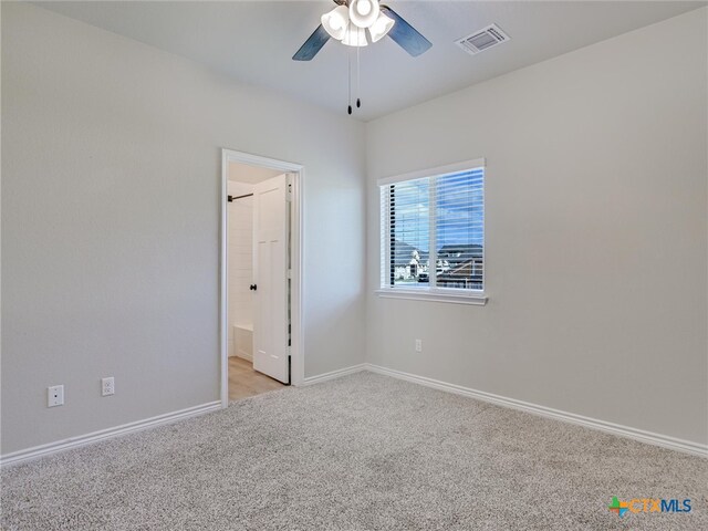 spare room with ceiling fan and light colored carpet