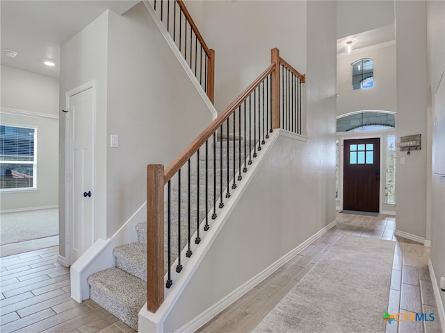 entryway with light wood-type flooring and a high ceiling