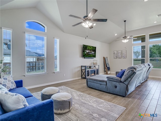 living room with high vaulted ceiling, hardwood / wood-style flooring, and ceiling fan