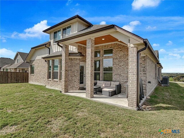 rear view of house with central AC unit, outdoor lounge area, a yard, and a patio area