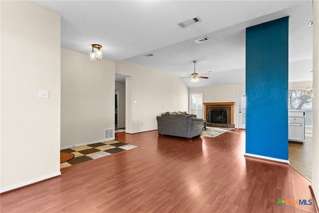 unfurnished living room featuring ceiling fan, a fireplace, hardwood / wood-style floors, and vaulted ceiling