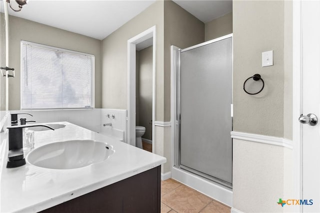 bathroom featuring tile patterned flooring, vanity, toilet, and a shower with shower door