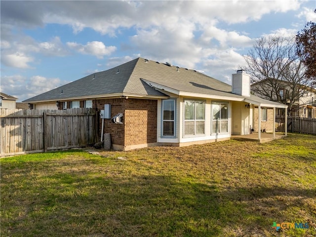 rear view of house with a yard and a patio