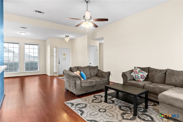 living room with ceiling fan and dark wood-type flooring