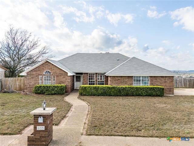 single story home featuring a front lawn