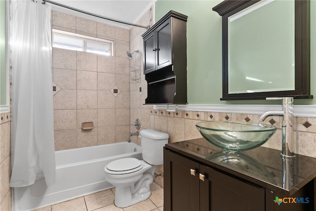 full bathroom with shower / bath combo, tile patterned flooring, toilet, vanity, and tile walls