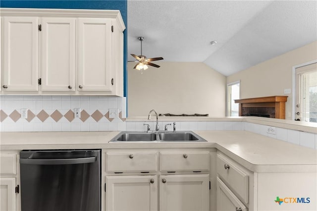 kitchen with stainless steel dishwasher, white cabinetry, lofted ceiling, and sink