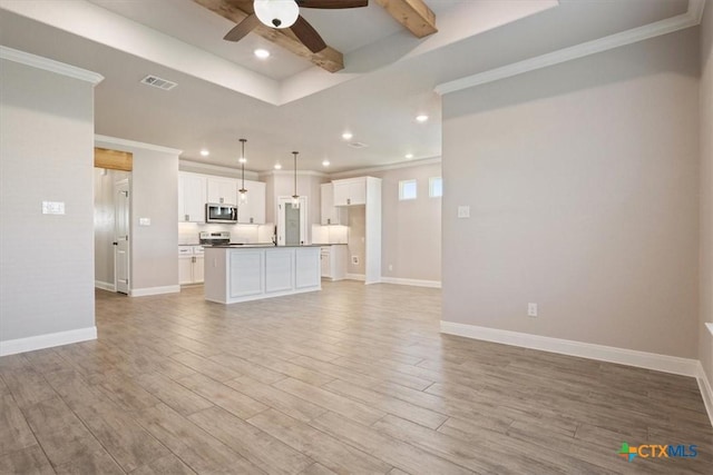 unfurnished living room with a tray ceiling, light hardwood / wood-style flooring, ceiling fan, and ornamental molding