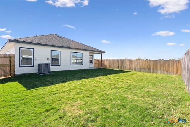 back of house featuring a yard and central AC