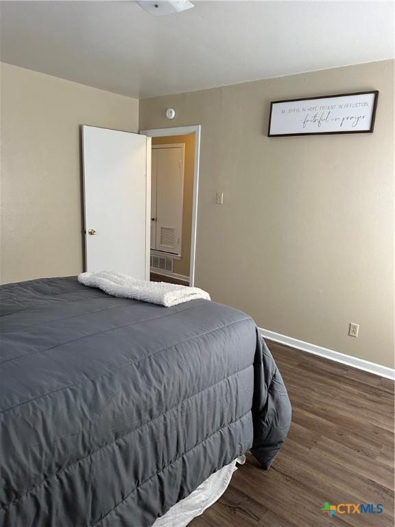 bedroom with wood finished floors and baseboards