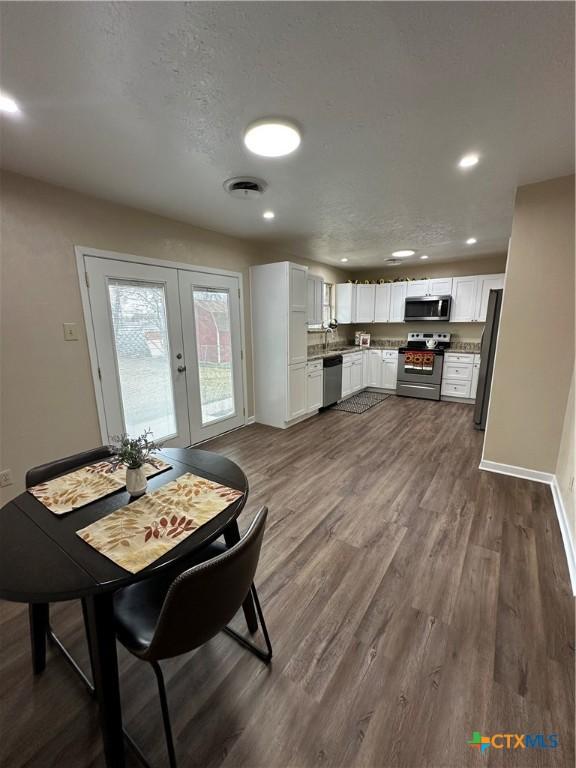 dining space with french doors, dark wood-style flooring, recessed lighting, visible vents, and a textured ceiling