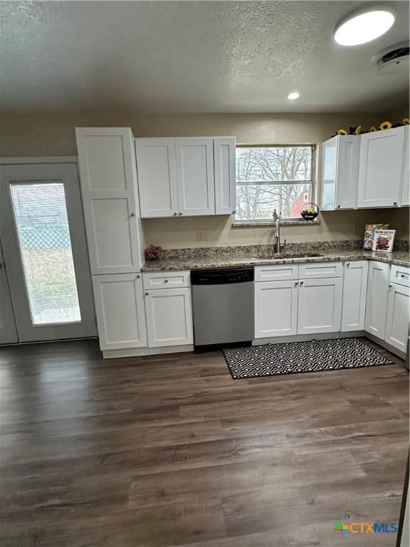 kitchen featuring dark wood finished floors, white cabinets, dishwasher, and a sink