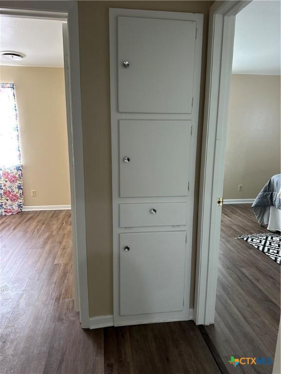 interior space featuring dark wood-style floors and baseboards