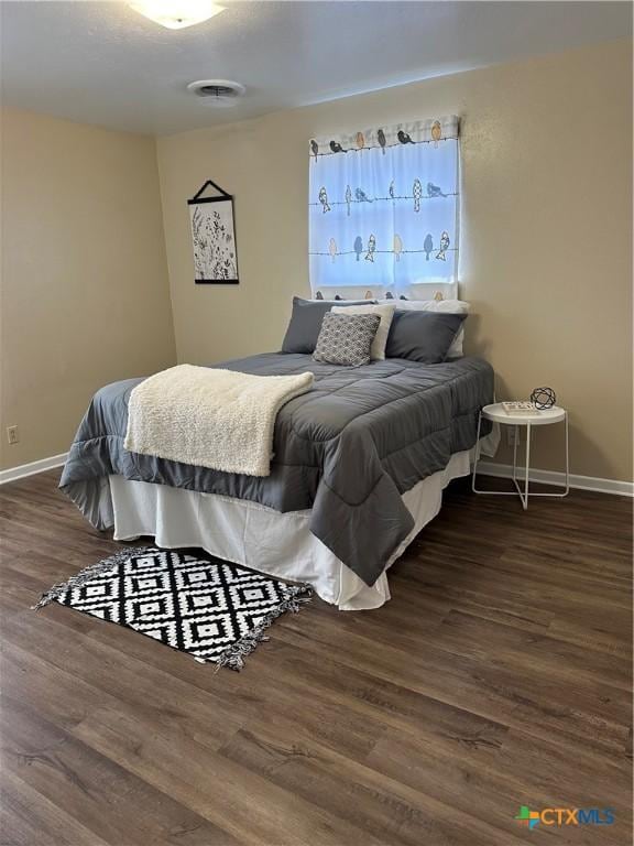 bedroom featuring baseboards and wood finished floors