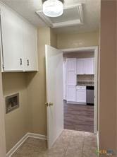 washroom featuring washer hookup, tile patterned flooring, cabinet space, and baseboards