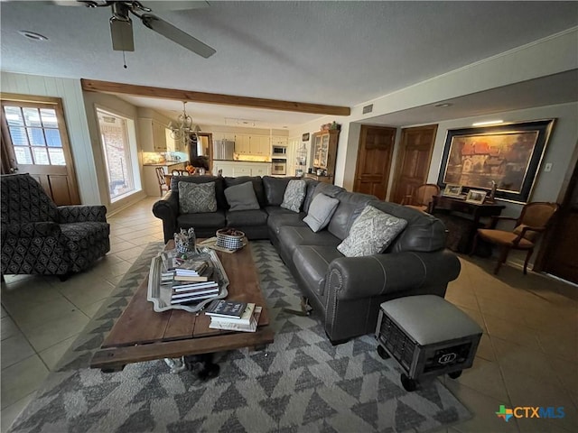 living room with tile patterned flooring, beam ceiling, and ceiling fan