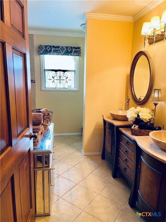 bathroom with vanity, crown molding, and tile patterned floors