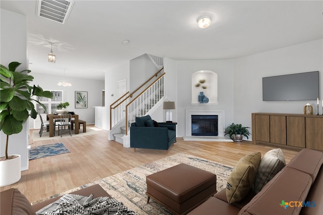 living room featuring an inviting chandelier and light hardwood / wood-style flooring