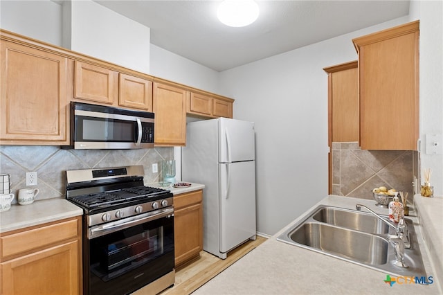 kitchen with light hardwood / wood-style floors, stainless steel appliances, sink, backsplash, and light brown cabinets