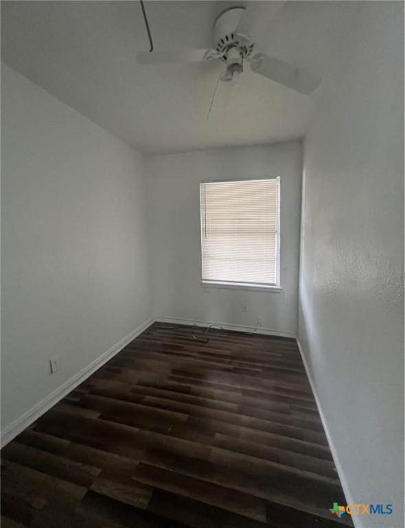 spare room featuring a ceiling fan, baseboards, and wood finished floors