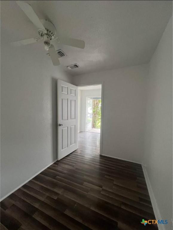 interior space featuring visible vents, a ceiling fan, and dark wood-type flooring