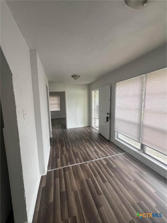 unfurnished living room featuring baseboards and wood finished floors