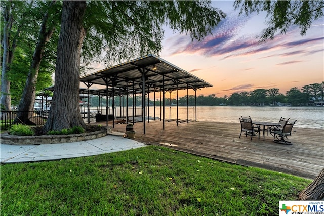 dock area with a yard and a water view