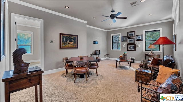 carpeted dining space featuring ceiling fan, a healthy amount of sunlight, and crown molding