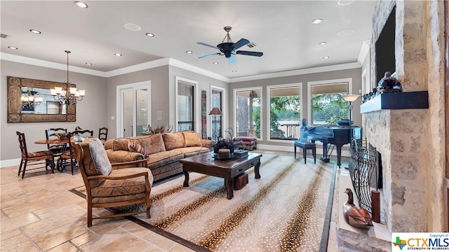 living room with ceiling fan with notable chandelier, a fireplace, and crown molding