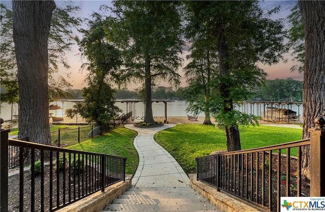 view of home's community with a water view and a yard