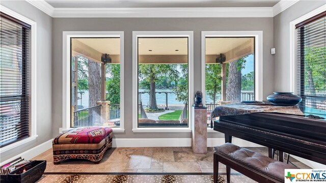 doorway to outside featuring a wealth of natural light, a water view, and crown molding