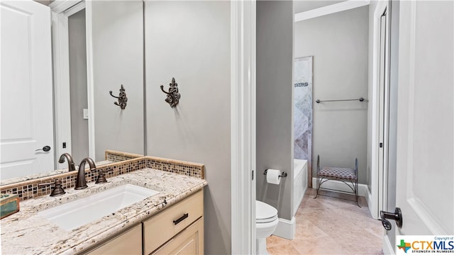 bathroom featuring toilet, vanity, and ornamental molding