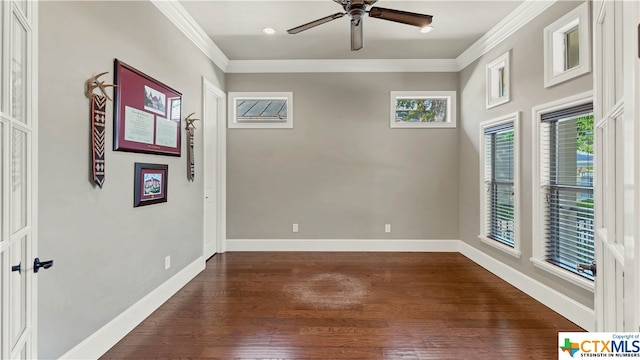 empty room with ornamental molding, a healthy amount of sunlight, and dark hardwood / wood-style floors