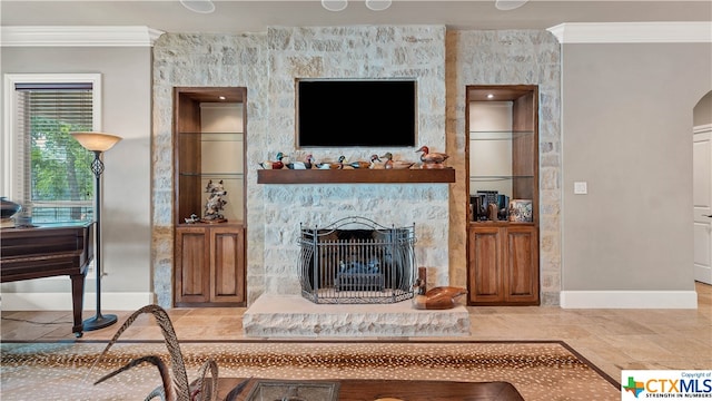 living room with a stone fireplace and ornamental molding