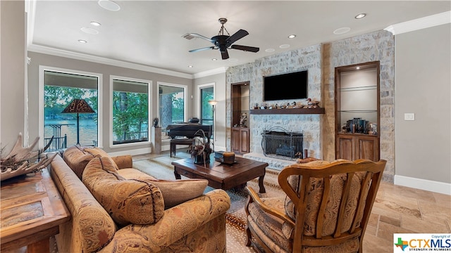 living room with ceiling fan, crown molding, and a fireplace