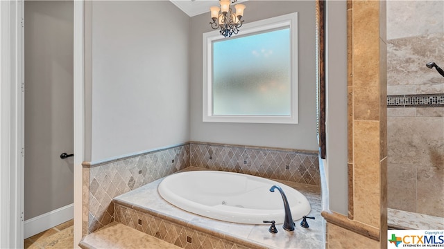 bathroom featuring independent shower and bath, a chandelier, and a healthy amount of sunlight